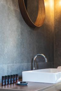 a bathroom with a white sink and a mirror at DESIGN hotel VERBENICUM in Vrbnik +37 photos