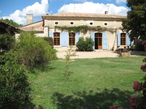 una casa grande con un patio delante en Chambres d'hôtes Le Chardon Fleuri, en Teuillac
