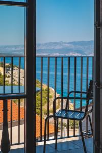 a chair on a balcony looking out at the ocean at DESIGN hotel VERBENICUM in Vrbnik