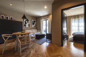 a bedroom and living room with a table and a bed at DESIGN hotel VERBENICUM in Vrbnik