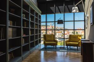 two chairs in a library with a view of a city at DESIGN hotel VERBENICUM in Vrbnik