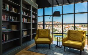two chairs in a library with bookshelves at DESIGN hotel VERBENICUM in Vrbnik