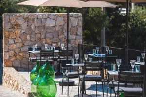 an outdoor restaurant with tables and chairs with wine glasses at DESIGN hotel VERBENICUM in Vrbnik