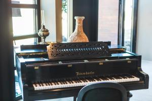 a black piano sitting on a table with a vase at DESIGN hotel VERBENICUM in Vrbnik