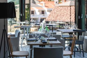 a restaurant with tables and chairs with wine glasses at DESIGN hotel VERBENICUM in Vrbnik