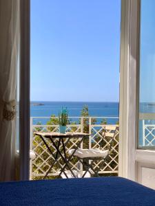 un tavolo e sedie su un balcone con vista sull'oceano di Mare Blu a Sapri