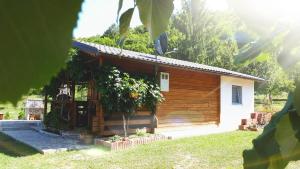 a small wooden house with the sun in the background at Studio apartman Firdaus-Bihać, Dobrenica bb in Bihać