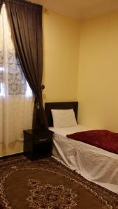 a bedroom with two beds and a window at العييرى للوحدات المفروشة تبوك6 in Tabuk