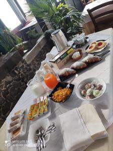 uma mesa com alimentos e bebidas para o pequeno almoço em Il noceto dell'Etna em Giarre