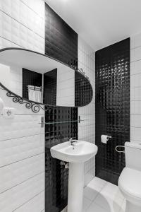 Baño en blanco y negro con lavabo y aseo en Hostal Los Ángeles, en Madrid