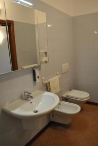 a bathroom with a sink and a toilet and a mirror at OTB Italia 1 - Luminoso appartamento tra Venezia e Treviso con Terrazza e Posto auto Coperto in Preganziol