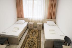 a room with two beds and a window at Гостиница Kokshe Inn in Kokshetau