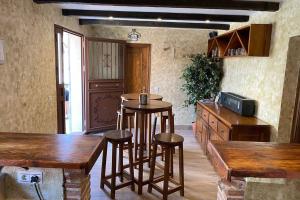 a kitchen with a bar with stools and a counter at Casa Tijeras I in Sotillo de las Palomas