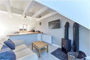 a living room with a couch and a stove at Host & Stay - Castle View in Seahouses