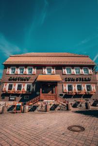 ein braunes Gebäude mit einem rot-weißen Gebäude in der Unterkunft Landgasthof Zum Stern Wasserkuppe Rhön in Poppenhausen