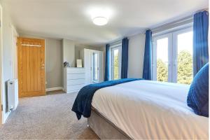 a bedroom with a large bed with blue curtains at Host & Stay - Castle View in Seahouses