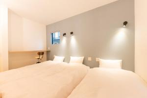 two beds in a room with white walls at 強羅base A棟 - GORA Base A in Gora