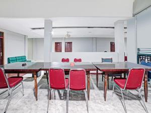 Hagu的住宿－OYO 90487 Wisma Kuta Karang Baru，一间会议室,配有大桌子和椅子