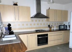 a kitchen with wooden cabinets and a stove top oven at Gite de Parcey in Parcey