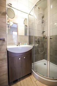 a bathroom with a sink and a shower at Aparthotel WADOWICE & Hostel GENERY in Wadowice