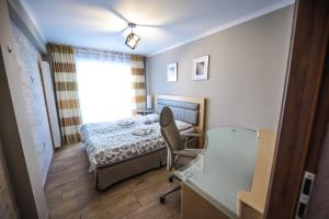 a bedroom with a bed and a chair and a window at Aparthotel WADOWICE & Hostel GENERY in Wadowice