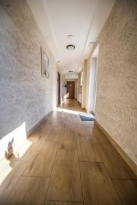 un pasillo vacío con suelo de madera y pared en Aparthotel WADOWICE & Hostel GENERY, en Wadowice