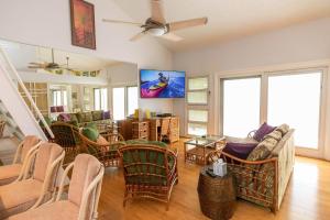 ein Wohnzimmer mit Stühlen und einem TV an der Wand in der Unterkunft Makani A Kai Resort B-7 in Wailuku