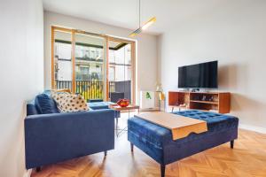 salon z niebieską kanapą i telewizorem w obiekcie Tropica Garden - Nowe Kolibki w mieście Gdynia
