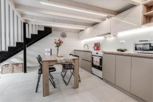 a kitchen with a wooden table and a staircase at Olea Apartment in Corfu Town +4 photos