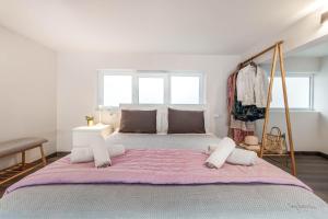 a bedroom with a large bed with a pink blanket at Olea Apartment in Corfu Town
