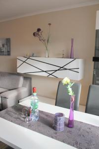 - un salon avec une table, une bouteille et des fleurs dans l'établissement Strandschloss, Whg 26, à Grömitz