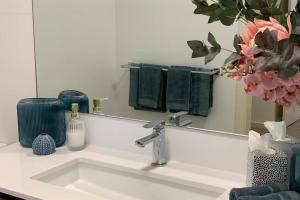 a bathroom sink with a mirror and green towels at Mariner's Cove ~ Luxe Waterfront Apartment in Mindarie +37 photos