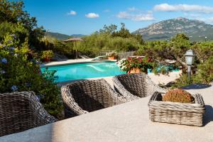 un tavolo con due sedie di vimini accanto alla piscina di Esclusiva Villa con piscina a Porto Rotondo