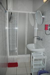 La salle de bains blanche est pourvue d'une douche et d'un lavabo. dans l'établissement Ośrodek Wypoczynkowy Pod Stokiem, à Karpacz