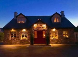 una casa de piedra con una puerta roja por la noche en Private Room with Private Entrance. en Galway