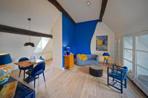 uma sala de estar com paredes azuis e uma mesa e cadeiras em Hotel Abdijhof Thorn em Thorn