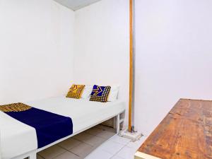 Ένα ή περισσότερα κρεβάτια σε δωμάτιο στο SPOT ON 90586 Hagawa Syariah Homestay