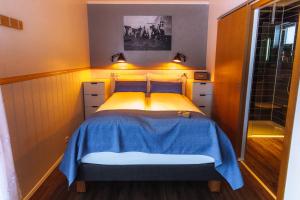 um pequeno quarto com uma cama com um cobertor azul em Nordic Natura em Garður