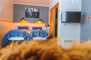 a bedroom with two beds and a flat screen tv at Nordic Natura in Skinnastadur