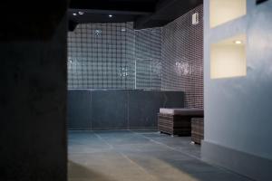 um quarto escuro com um banco e paredes de tijolo em Casa Jungle Slps 20 Mcr Centre Hot tub, bar and cinema Room Leisure suite em Manchester
