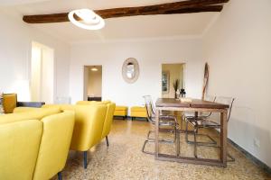 a living room with yellow chairs and a wooden table at CasaViva - Elegante casa con dehors a Camogli in Camogli