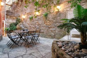 a patio with a table and chairs and a stone wall at CasaViva - Elegante casa con dehors a Camogli in Camogli