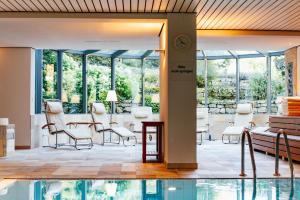 um átrio com uma mesa e cadeiras e uma piscina em Hotel Benther Berg em Ronnenberg