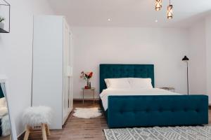 皮亚特拉-尼亚姆茨Scandinavia Residence的一间卧室设有蓝色的床和白色的墙壁