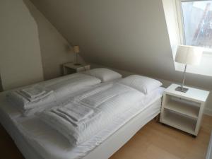 uma cama branca com toalhas num quarto em Bright apartment in historic City Center em Copenhague