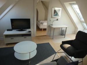 a living room with a couch and a tv at Bright apartment in historic City Center in Copenhagen