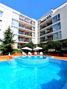 a swimming pool in front of a large apartment building at Sineva Del Sol Apartments in Sveti Vlas