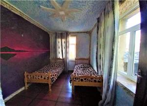 a room with two beds in a room with a window at Guesthouse ZAMO in Ushguli