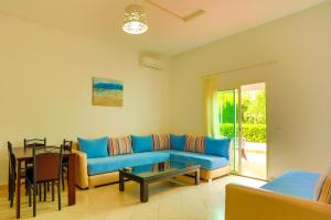 sala de estar con sofá azul y mesa en Résidence Hôtelière Riviera Beach en Cabo Negro