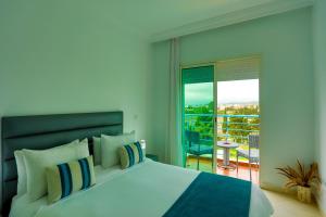 a bedroom with a large bed and a balcony at Résidence Hôtelière Riviera Beach in Cabo Negro